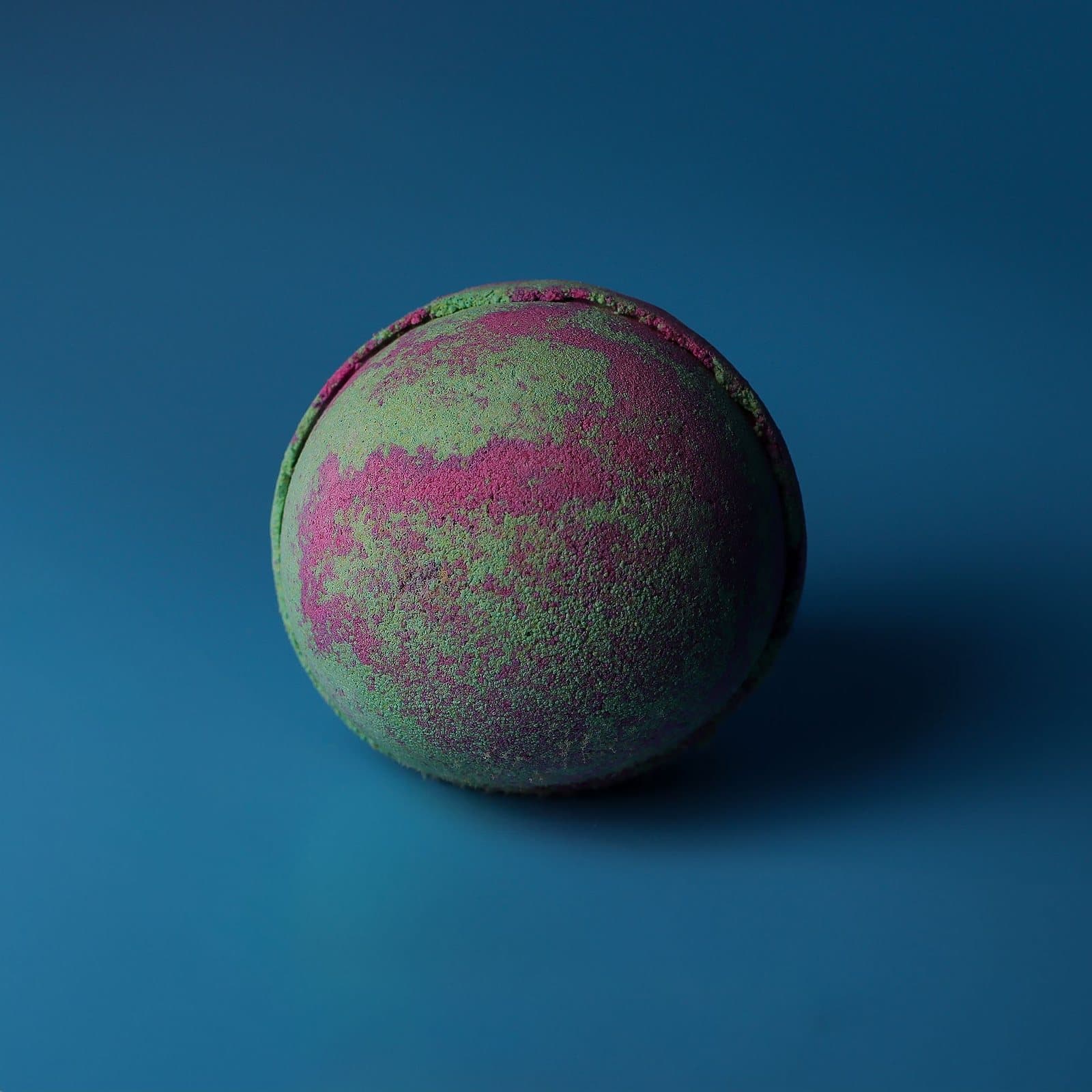 Three marbled green and pink bath bombs