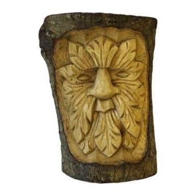 Small tree trunk wood carving of a green man face