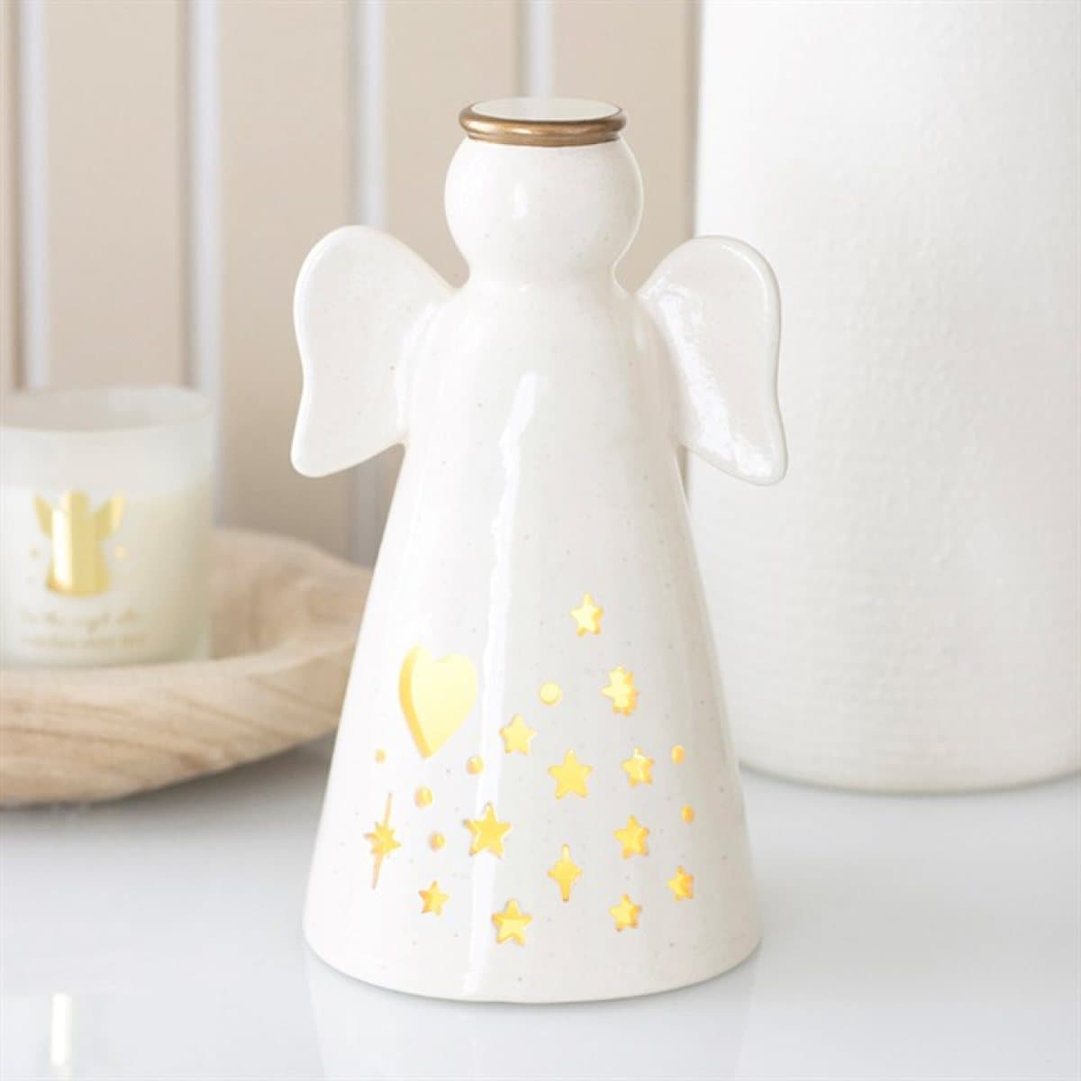 Small off-white ceramic angel with gold halo and glowing heart and star cut-outs