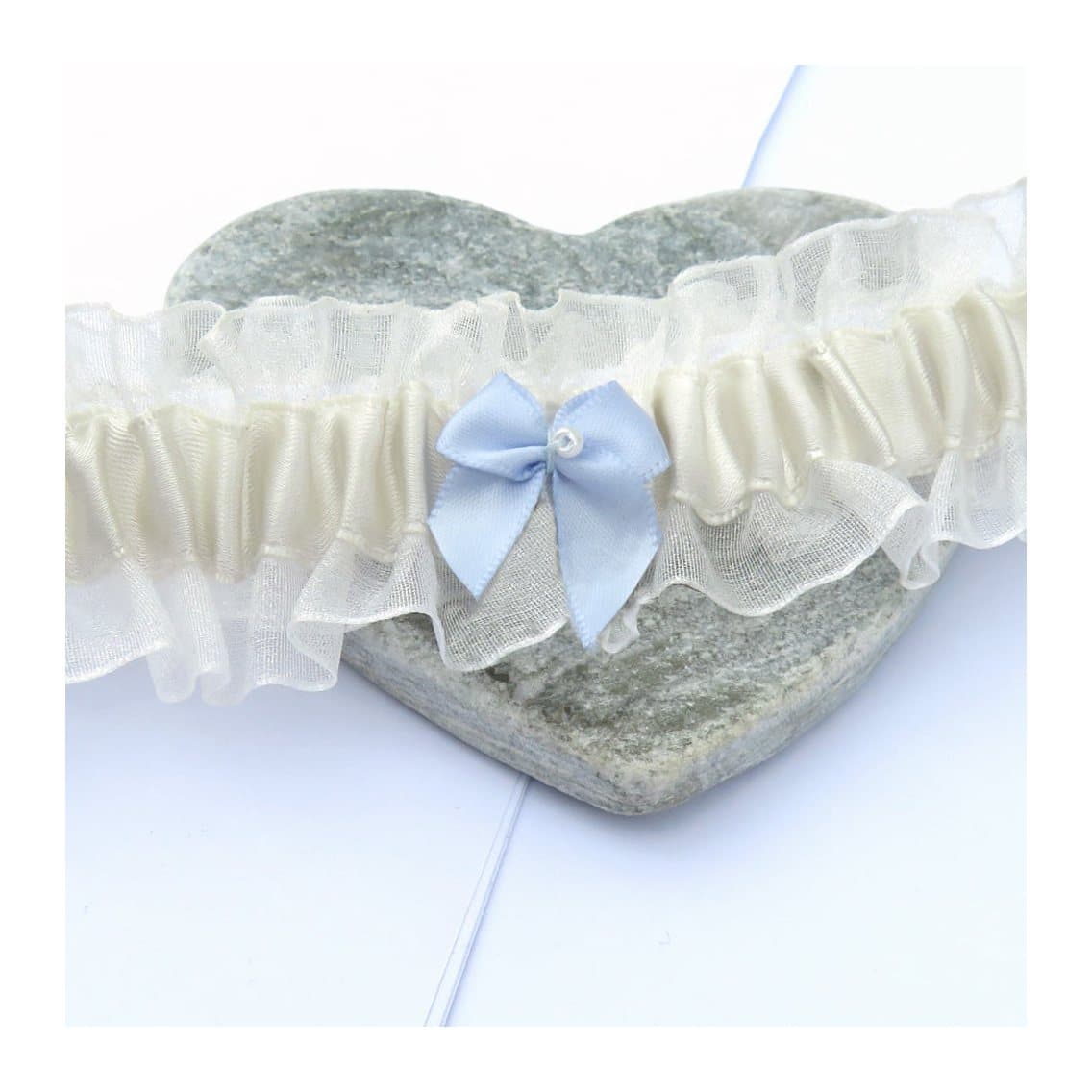 Ivory satin wedding garter with a blue bow and small pearl