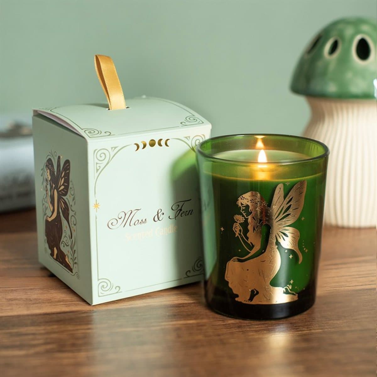 Green glass candle with a golden fairy design