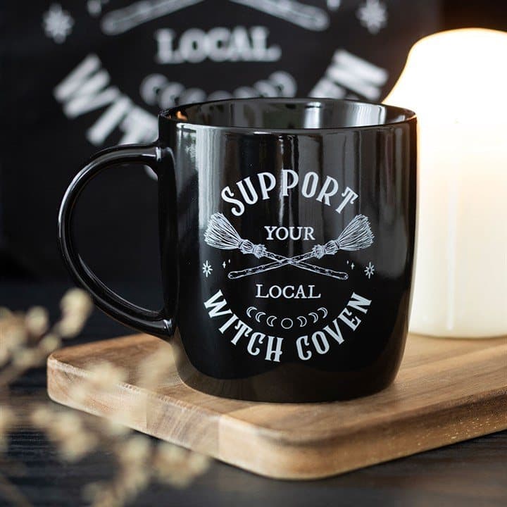 Black mug with crossed broomsticks and a witch coven slogan