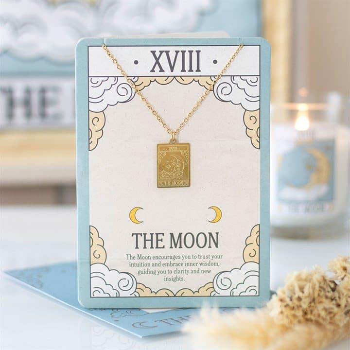Gold-toned Moon tarot pendant necklace on an illustrated greeting card