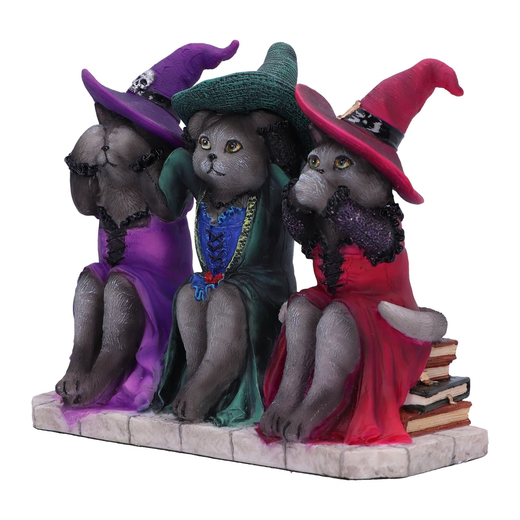 Three cat figures in witch outfits, perched on stacks of books