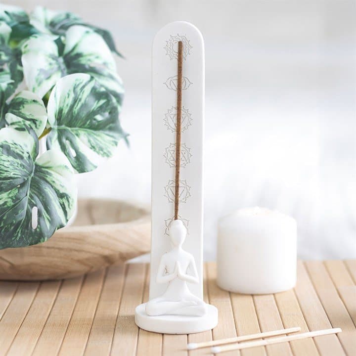 White ceramic incense stick holder with chakra symbols and a seated lotus figure