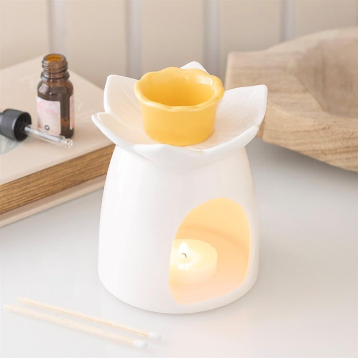 White ceramic oil burner and wax warmer with a daffodil design